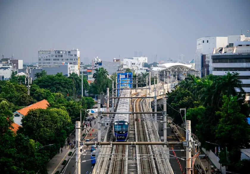 ジャカルタの市街地で、屋根付きの高架鉄道を走る通勤電車。