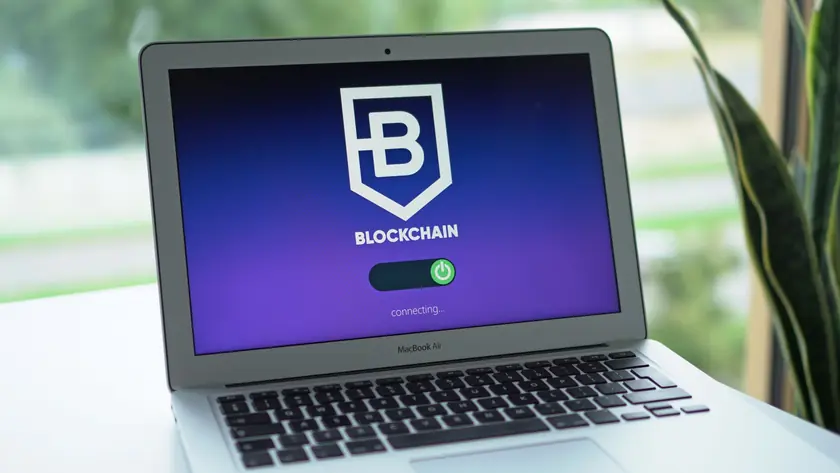 A laptop screen displays a blockchain interface, highlighting digital finance technology.